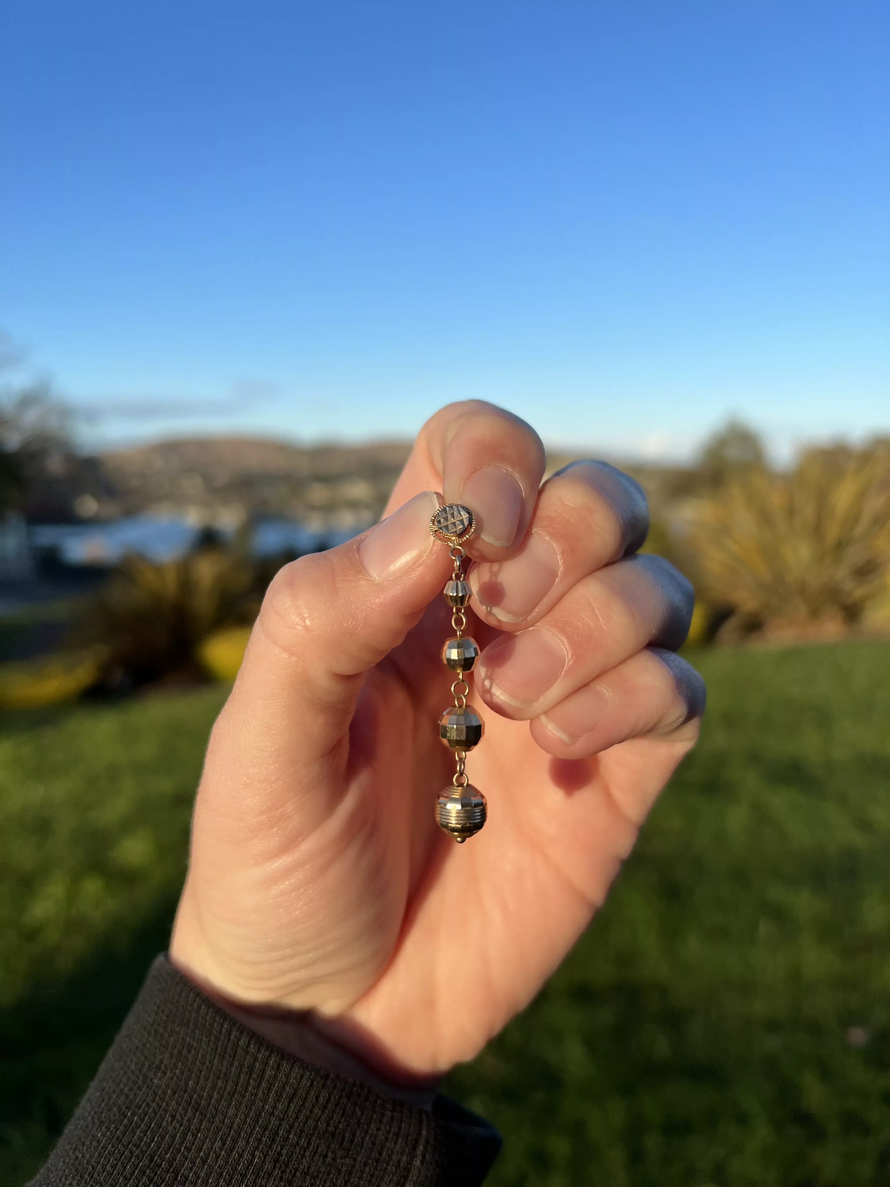 Missing necklace pendant recovered - hand showing the pendant