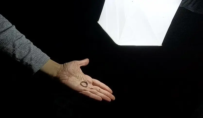 Mens wedding ring shown in the hand of its owner after recovery on hillside.