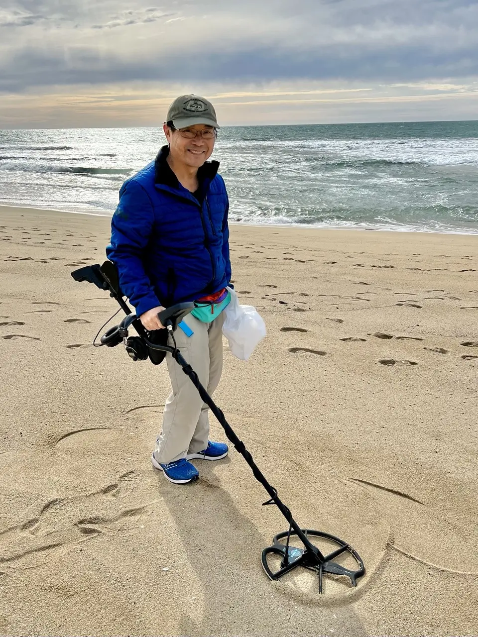 Metal detecting lesson student stands on a San Francisco Bay Area beach